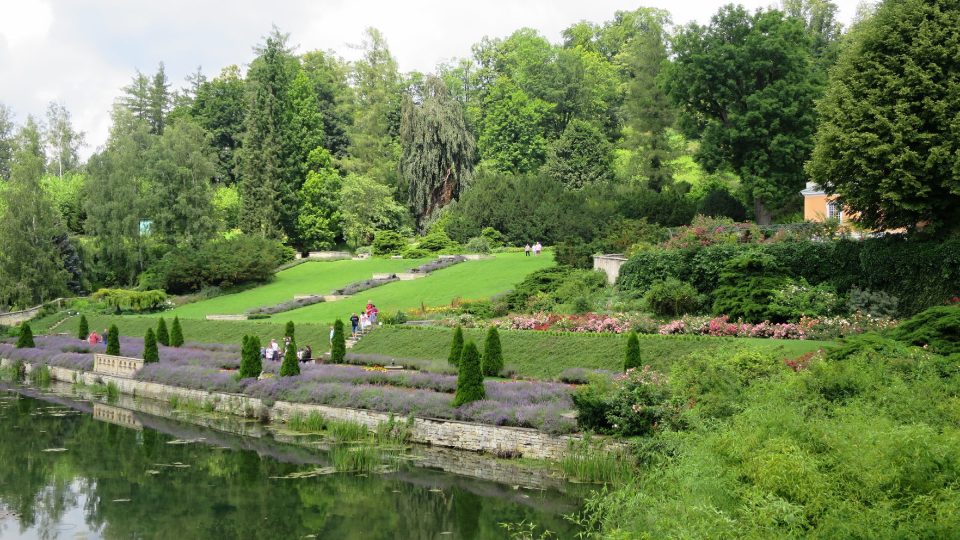 Pohled přes zámecký rybník na vodní kaskádu a rosarium