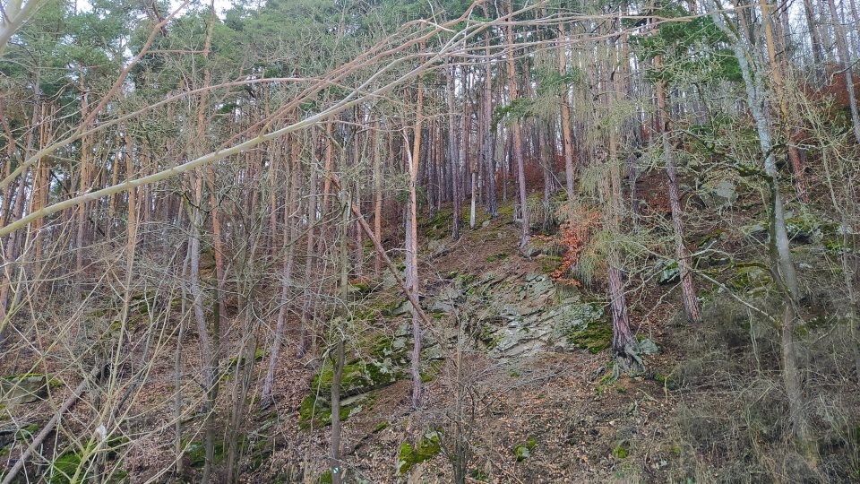 Skály tyčící se nad silnicí naproti Červenému mostu