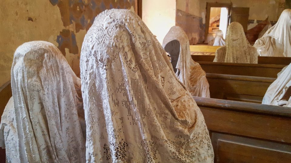 V kostele svatého Jiří v Lukově sedí v lavicích sochy duchů