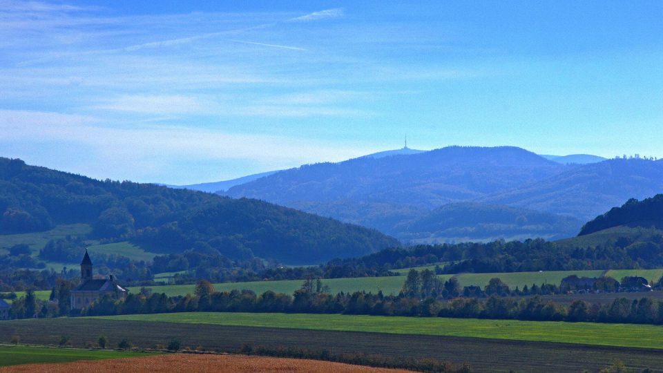 Kostel sv. Martina ve Skorošicích a v pozadí vrchol Pradědu s vysílačem